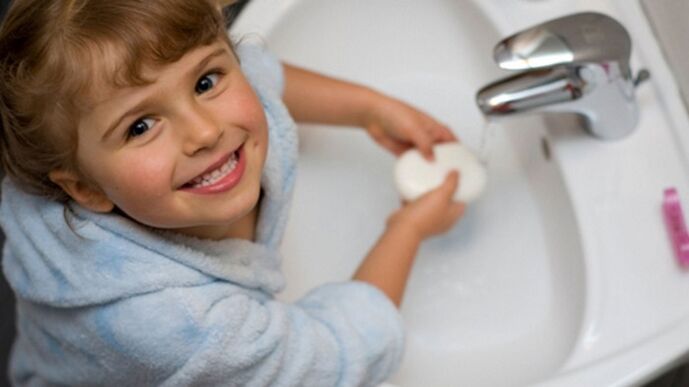 bērns tārpu novēršanai mazgā rokas ar ziepēm